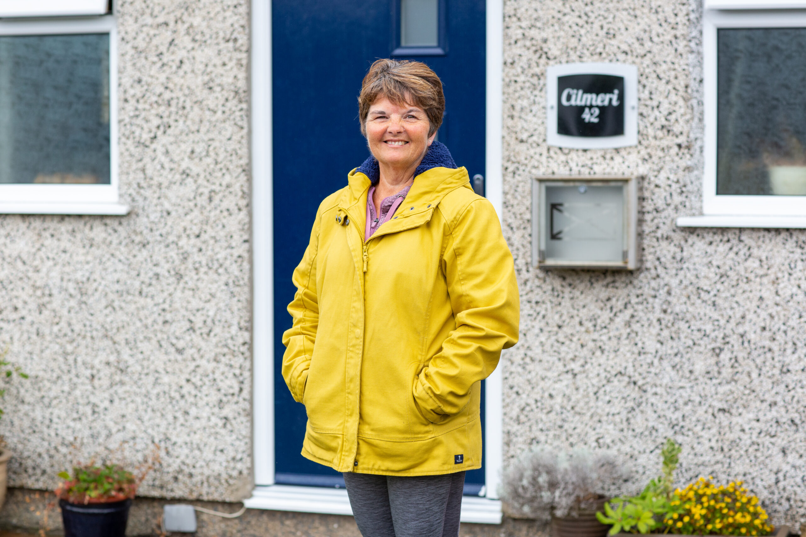 Woman standing outside house