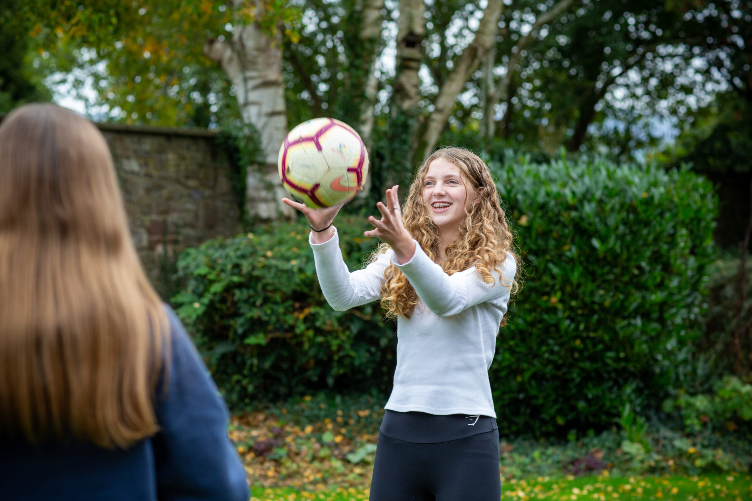 Teenage girl playing outside with ball